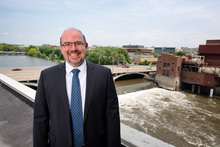 Gabriele Villarini on the roof of Stanley Hydraulics Lab with the river and campus behind him