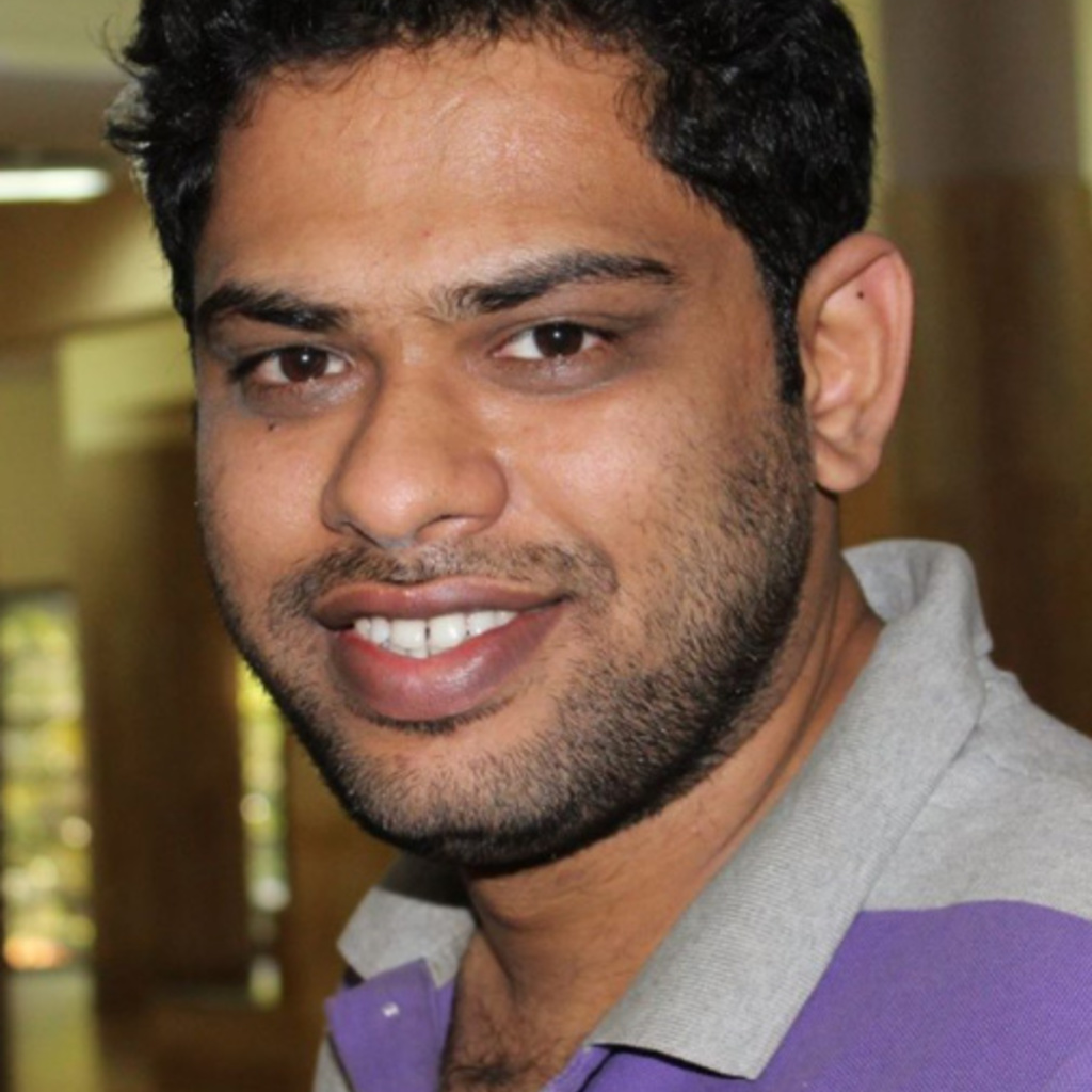A young man smiles at the camera