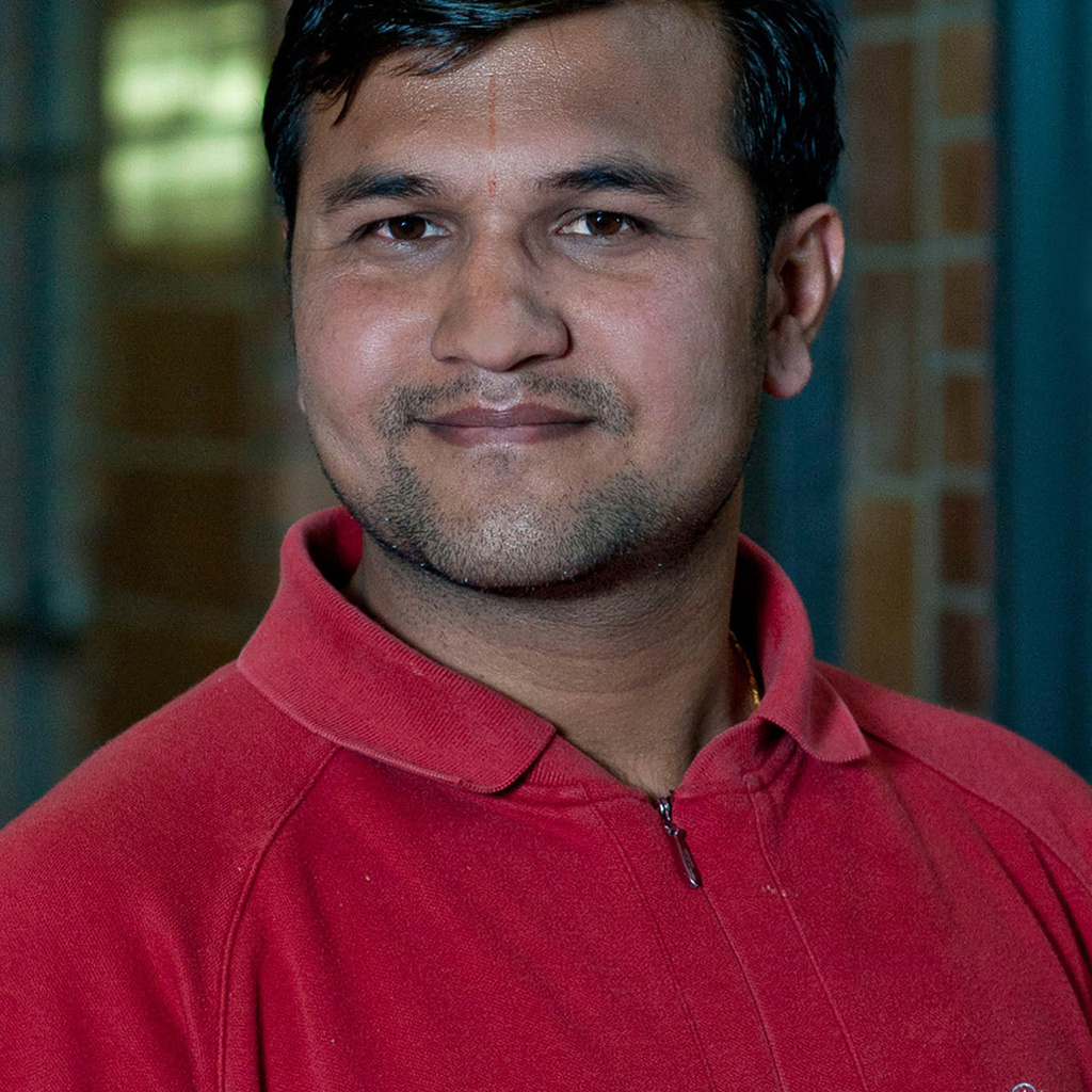 A young man smiles at the camera
